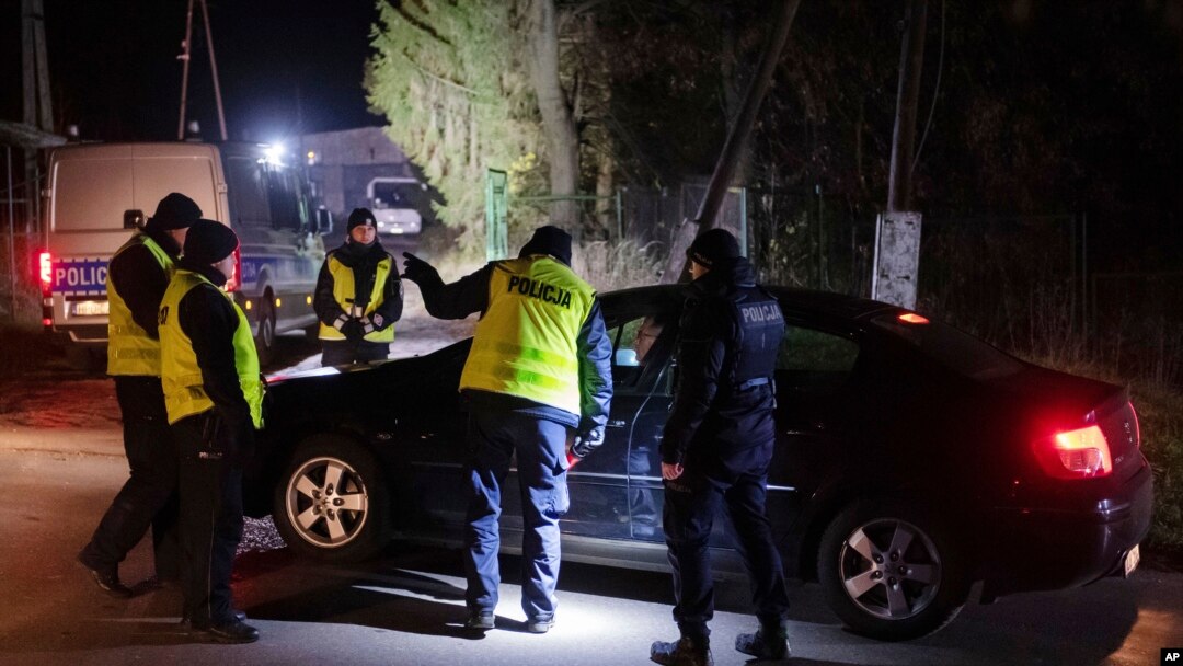 Los agentes de policía se reúnen frente a un depósito de granos en Przewodow, al este de Polonia, donde, según informes, un misil ruso extraviado causó una explosión que mató a dos personas, el 15 de noviembre de 2022.