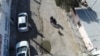 A las afueras del albergue El Buen Samaritano de Ciudad Juárez, México, niños migrantes miran hacia un dron que vuela sobre el edificio durante una visita de periodistas al área el 24 de enero 2024.