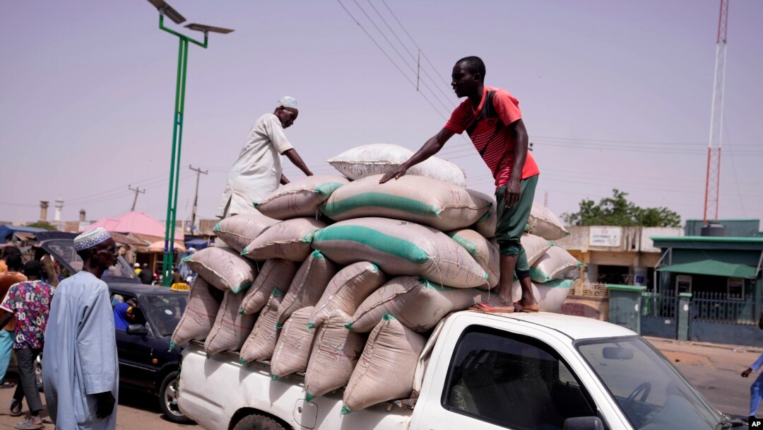 FILE - Workers offload bags of grains from a truck at a market in Gombe, Nigeria, June 3, 2024. 