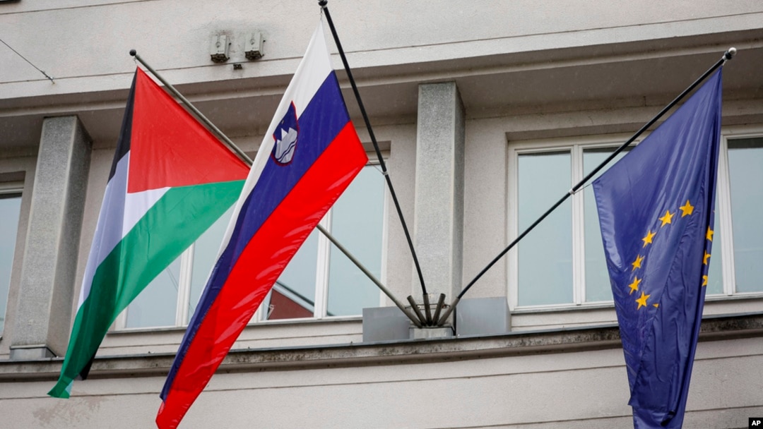 A Palestinian flag flies next to a Slovenian, center, and a European Union flag, right, at the government building in Ljubljana, Slovenia, May 30, 2024.