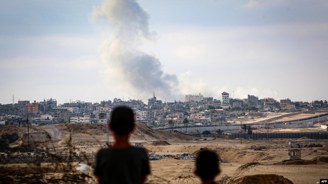 Niños observan el humo que se eleva durante los ataques israelíes al este de Rafah, en el sur de la Franja de Gaza, el 13 de mayo de 2024.