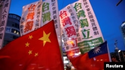 2016年5月14日，離台灣民選總統蔡英文就職典禮還有一個星期，支持台灣獨立和主張同中國大陸和平統一的台灣民眾舉著各自的旗幟上街遊行，表達各自的政治主張。（路透社）