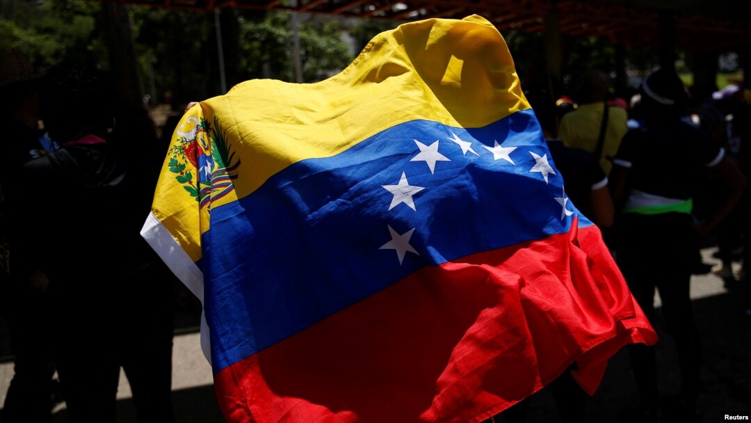 Un manifestante sostiene una bandera venezolana, mientras trabajadores sindicales, miembros de partidos políticos de oposición y otros participan en una protesta contra el gobierno venezolano, durante el día de Mayo, en Caracas, Venezuela, el 1 de mayo de 2023.