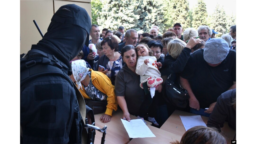 Evacuated people in the Kursk region line up to fill out forms for aid at a humanitarian distribution center in Kursk, Russia, Aug. 14, 2024.