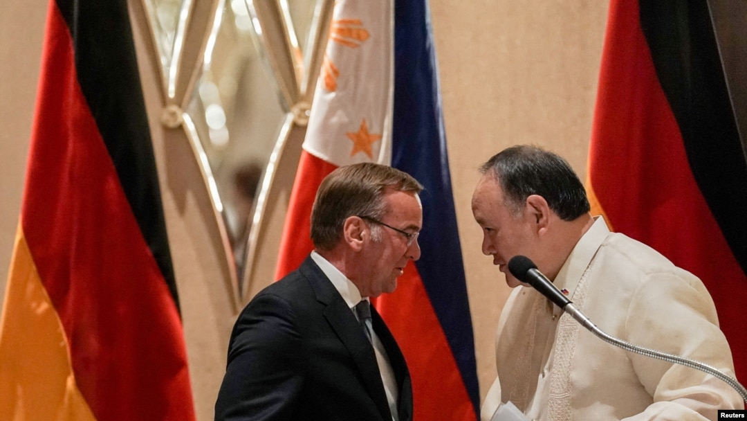 Philippine Defense Minister Gilberto Teodoro speaks with German Defense Minister Boris Pistorius as they shake hands after their joint news conference at a hotel in Makati, Metro Manila, Philippines, Aug. 4, 2024. 