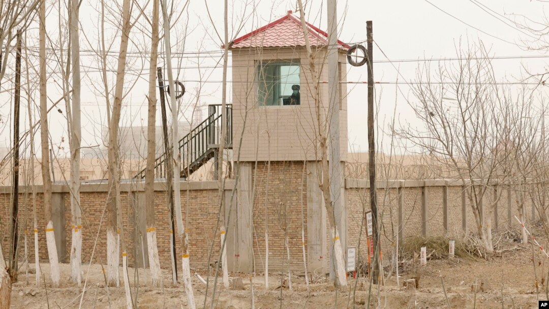 FILE - A security person watches from a guard tower around a detention facility in Yarkent County in northwestern China's Xinjiang Uyghur Autonomous Region on March 21, 2021.