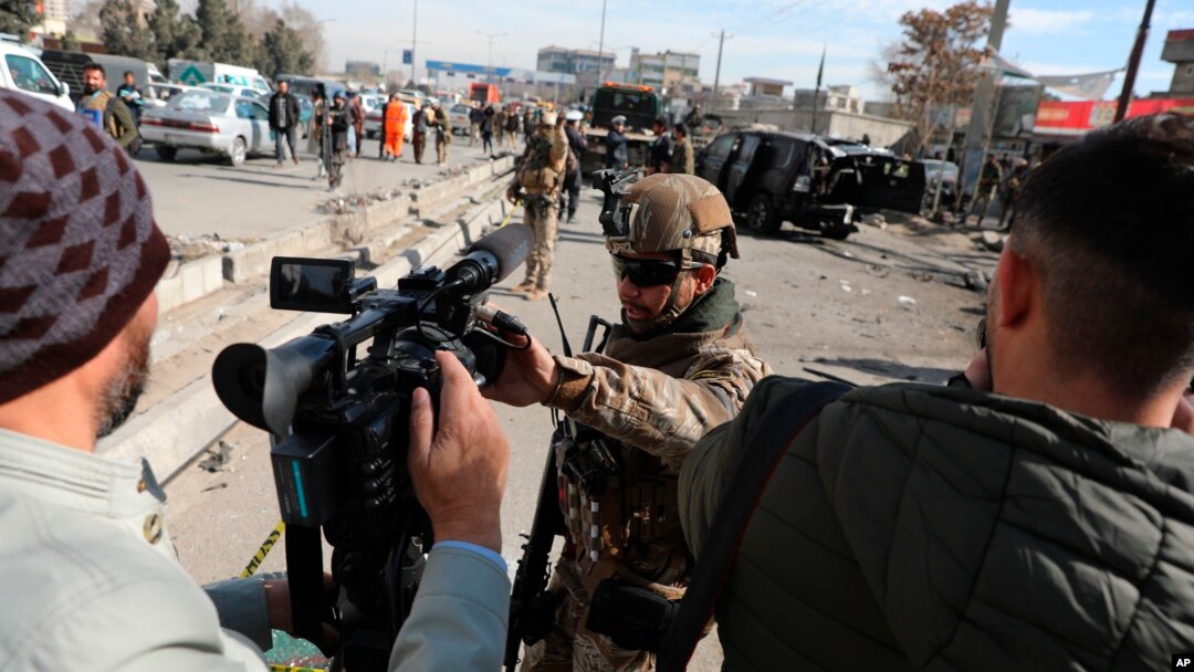 Afghan security police block a TV journalist from filming at the site of bombing attack in Kabul, Afghanistan, Feb. 10, 2021. 