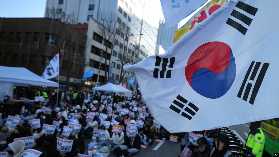 Participants hold signs during a rally calling on the Constitutional Court to dismiss the President Yoon Suk Yeol in Seoul, South Korea, Dec. 15, 2024. The signs read "Immediately arrest." 