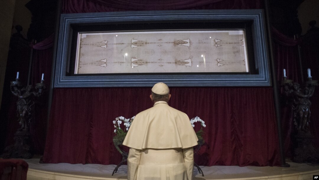 FILE - Pope Francis prays in front of the Holy Shroud of Turin, the 14 foot-long linen revered by Christians as the burial cloth of Jesus, on display at the Cathedral of Turin, Italy, June 21, 2015.