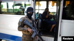 Un soldado salvadoreño custodia una unidad de transporte incautada en una terminal después de que el gobierno salvadoreño sancionara una ruta de autobús por violar las medidas de emergencia para aliviar los efectos de los altos precios del combustible, el 14 de marzo de 2022.