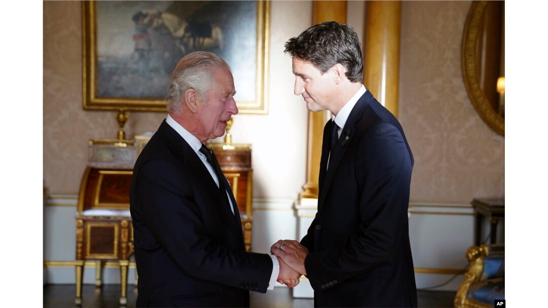 Britain's King Charles III shakes hands with Prime Minister of Canada Justin Trudeau, as he receives realm prime ministers in the 1844 Room at Buckingham Palace in London, Sept. 17, 2022.
