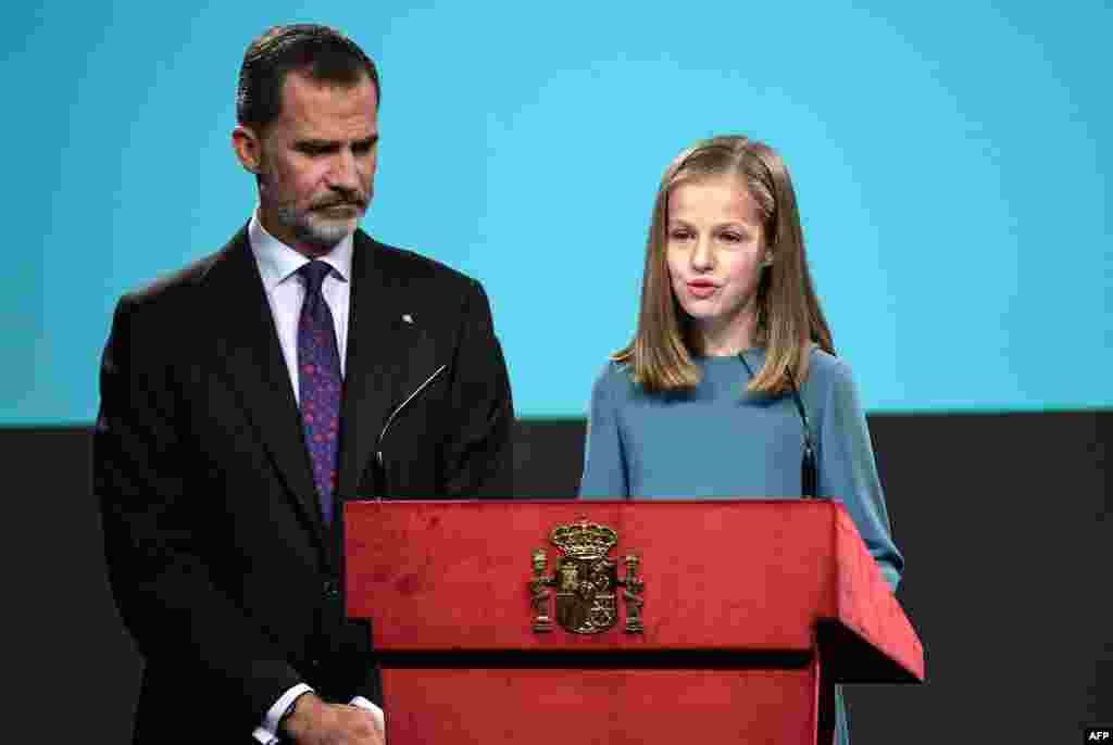 Spanish heiress to the throne, Princess Leonor (R), reads the Spanish Constitution under the watch of her father, King Felipe VI, during a ceremony marking 40 years of its approval by the parliament, at the Cervantes Institute in Madrid.