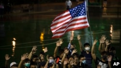 A demonstrator holds a U.S. flag during a rally in Hong Kong, Oct. 15, 2019. Protesters are upset with LeBron James over comments the L.A. Lakers star made about free speech during a rally in support of Houston GM Daryl Morey.