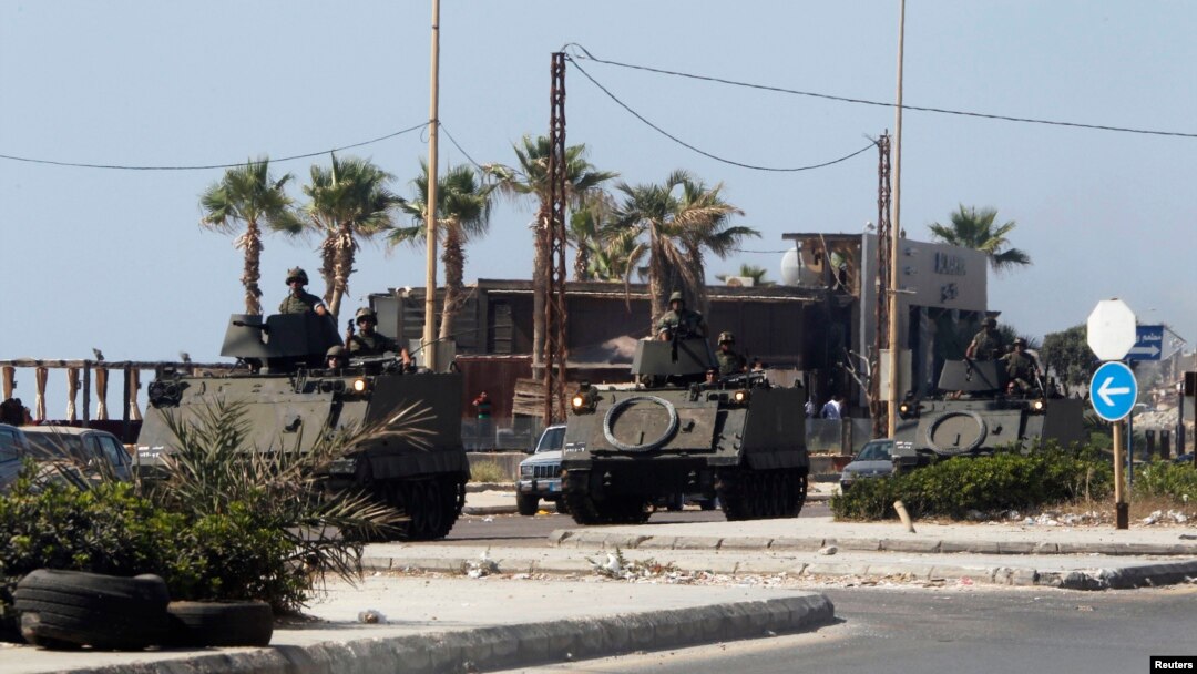 Lebanese Army soldiers on armored vehicles move towards an area of clashes in Sidon, southern Lebanon, June 23, 2013. 
