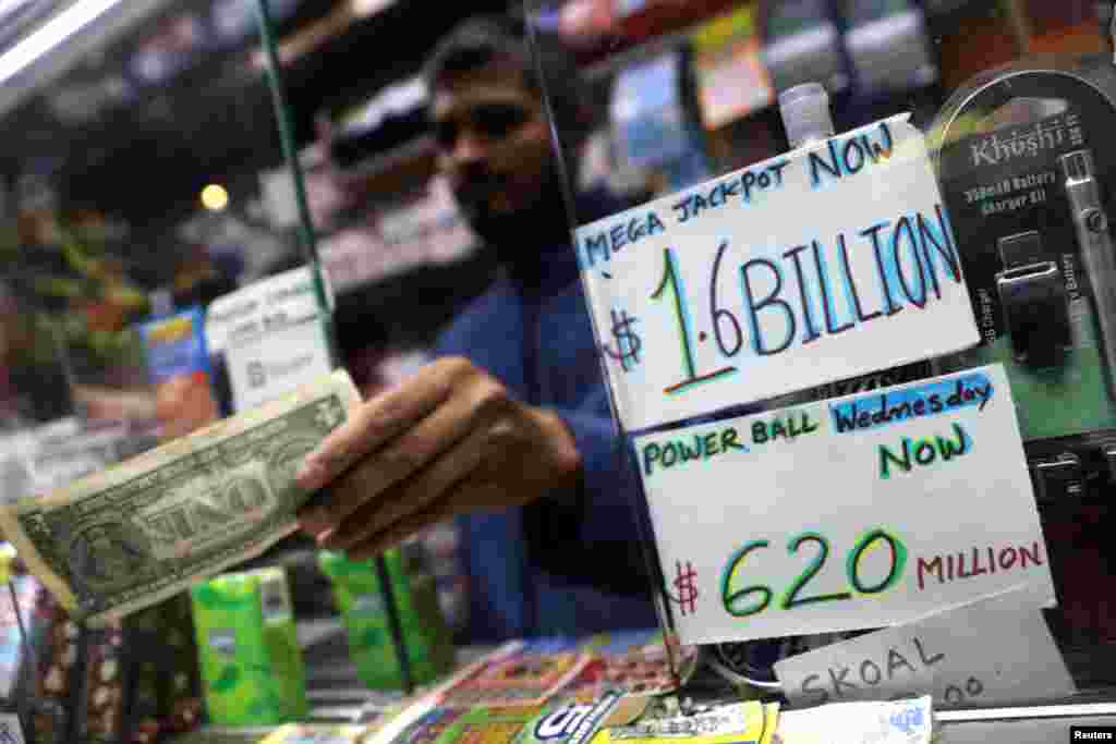 A newsstand vendor accepts a customer's payment for tickets in Tuesday's Mega Millions and Wednesday's Powerball lottery drawings in New York City, New York.