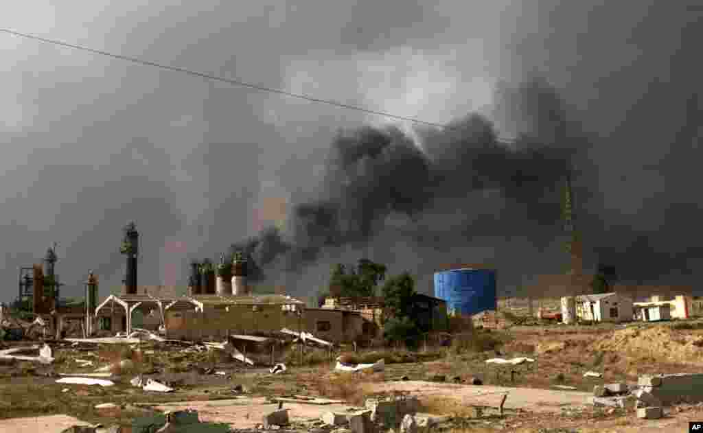 Oil wells on the edge of Qaraya Sunday August 28, 2016 burn days after the key town south of was retaken from the Islamic State group by Iraqi ground forces backed by U.S.-led coalition airpower.