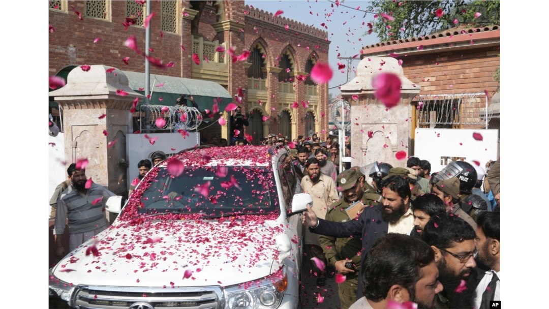 Supporters of Hafiz Saeed, head of Pakistan's Jamaat-ud-Dawa group, shower his car with rose petals as he leaves a court in Lahore, Pakistan, Nov. 21, 2017.