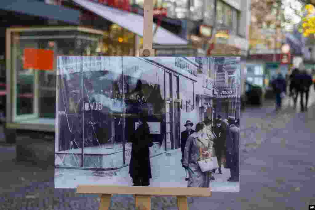 A Nov. 10, 1938 photo from the AP Archive, showing Jewish shops destroyed by Nazis at the Kurfuerstendamm street, is placed at the same location 80 years later in Berlin, Germany. On Nov. 9, 1938 Jews and their holdings were attacked across Nazi Germany - also known as Kristallnacht or Night of the broken glasses.