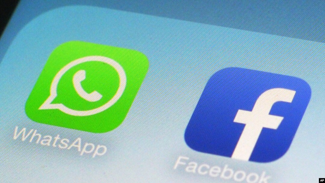 FILE - WhatsApp and Facebook app icons on a smartphone in New York. WhatsApp says it's now using a powerful form of encryption to protect the security of photos, videos, group chats and voice calls in addition to text messages sent by more than a billion users around the globe. (AP Photo/Patrick Sison, File)