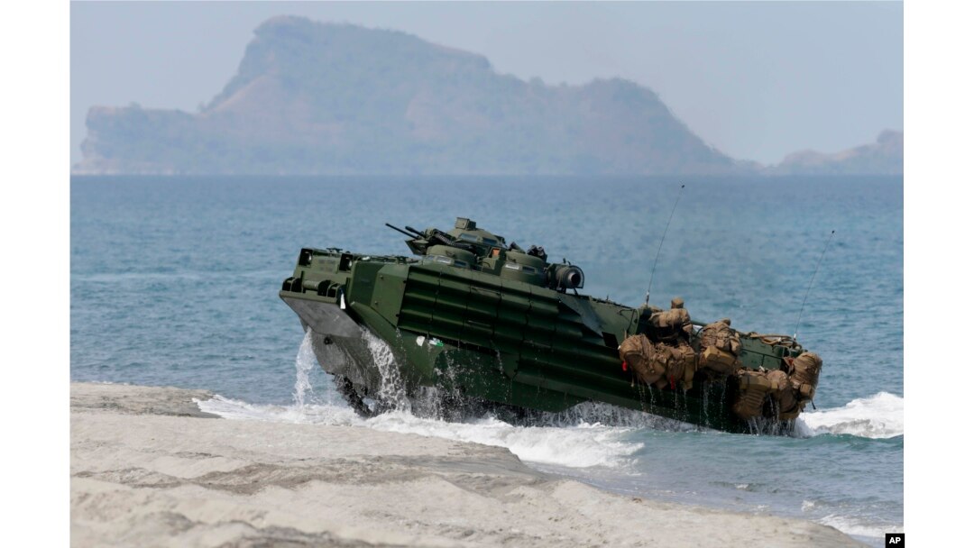 FILE - A U.S. Navy's amphibious assault vehicle with Philippine and U.S. troops on board storms the beach at a combined assault exercise at a beach facing one of the contested islands in the South China Sea known as the Scarborough Shoal in the West Philippine Sea Tuesday, April 21, 2015.