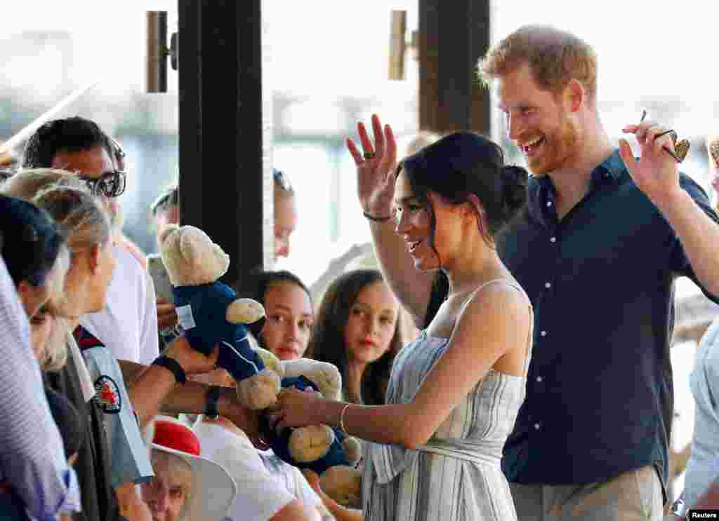 Britain&#39;s Prince Harry and Meghan, Duchess of Sussex, receive teddy bears as they greet members of the public in Kingfisher Bay on Fraser Island in Queensland, Australia.