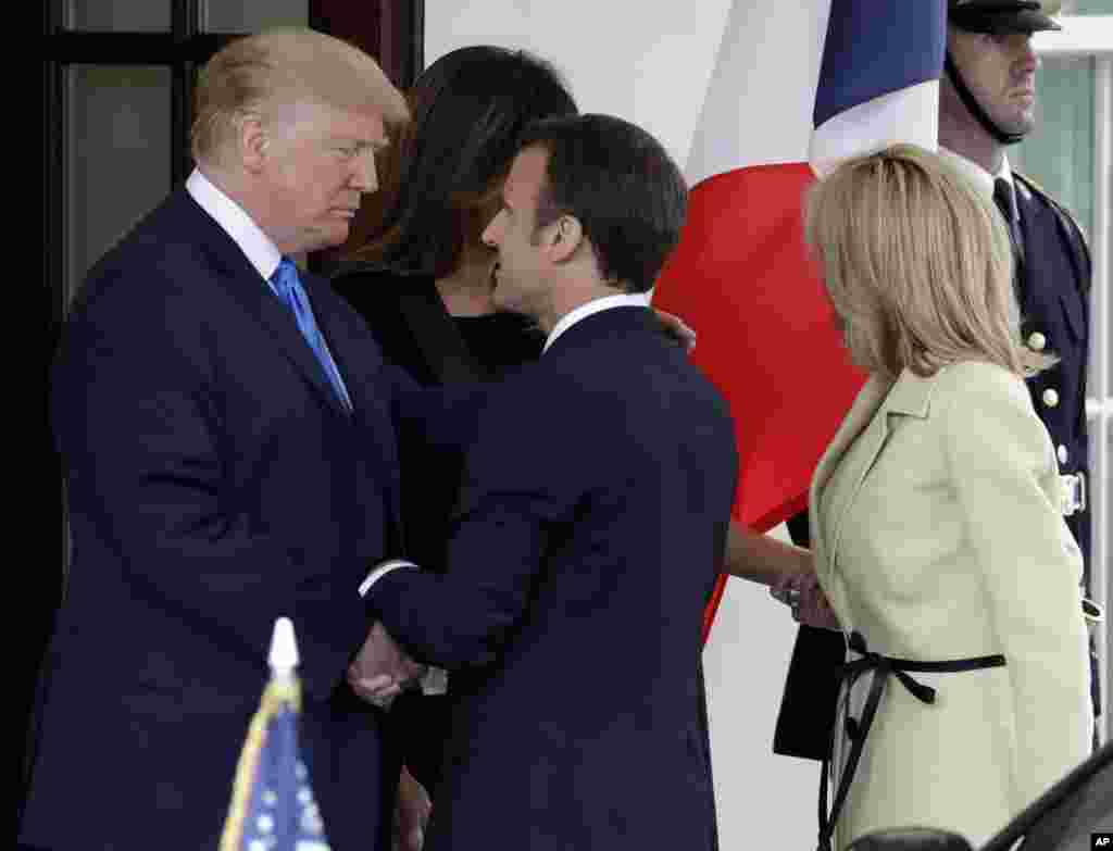 President Donald Trump and first lady Melania Trump greet French President Emmanuel Macron and his wife Brigitte Macron at the White House, April 23, 2018, in Washington. 