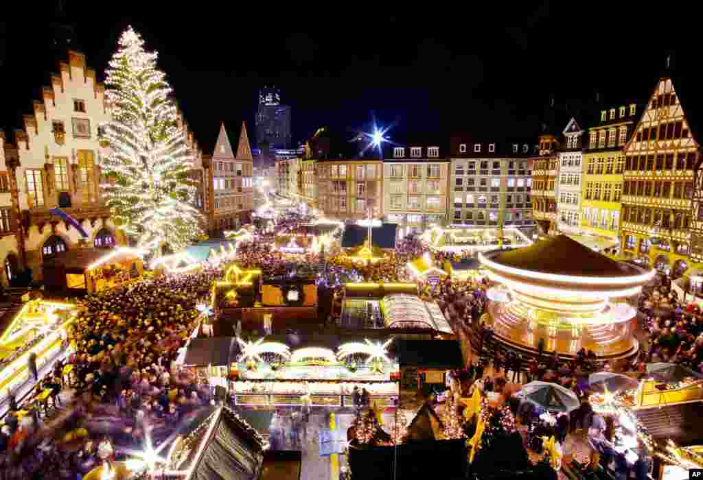 A merry-go-round turns as the Christmas tree is illuminated after the opening of the traditional Christmas market in Frankfurt, Germany.