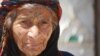 One-hundred-year-old Tamam Shaheen balked at IS orders to veil her face or quit smoking, but in the wake of IS rule, her grandson is now imprisoned and accused of having fought alongside the group, in Sarran, Syria, Aug. 18, 2017. (H. Murdock/VOA)