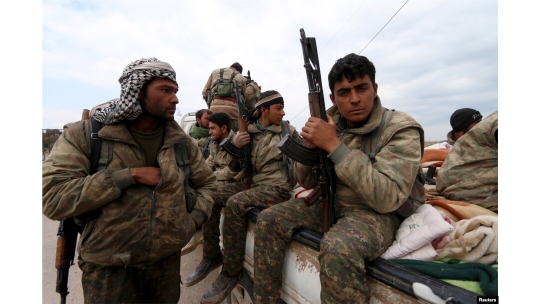 FILE - Kurdish People's Protection Units (YPG) fighters carry their weapons while riding on the back of a pick-up truck in Qamishli, Syria, March 11, 2016.