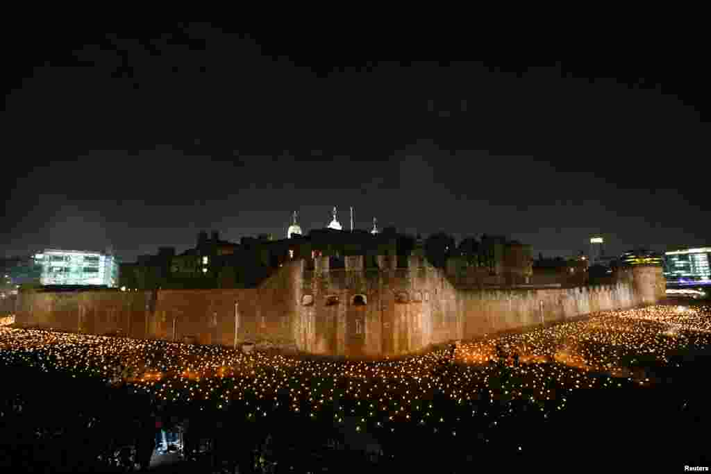 The moat of the Tower of London are seen filled with thousands of lit torches as part of the installation 'Beyond the Deepening Shadow', in London, Nov. 4, 2018.