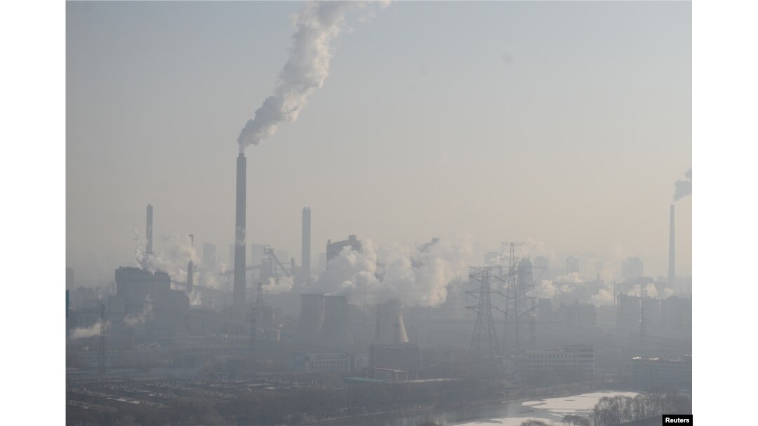 FILE - Smog billows from chimneys and cooling towers of a steel plant during hazy weather in Taiyuan, Shanxi province, China, Dec. 28, 2016.