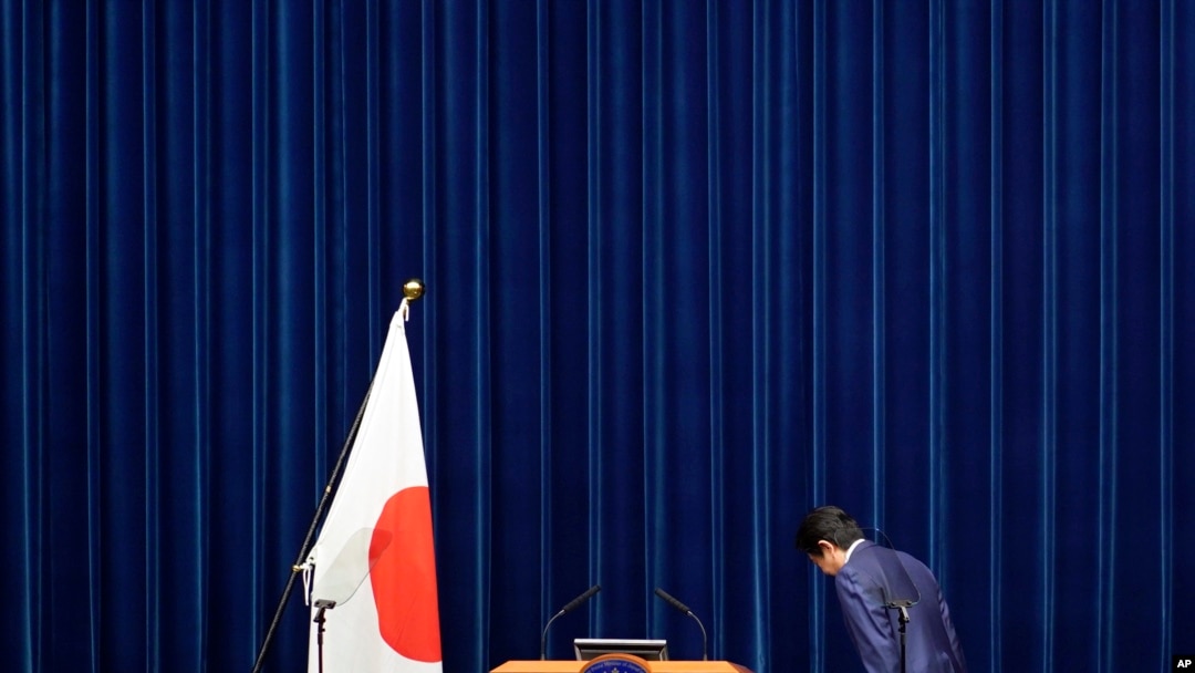 아베 신조 일본 총리가 14일 총리 관저에서 기자회견에 앞서 일장기를 향해 경례하고 있다.