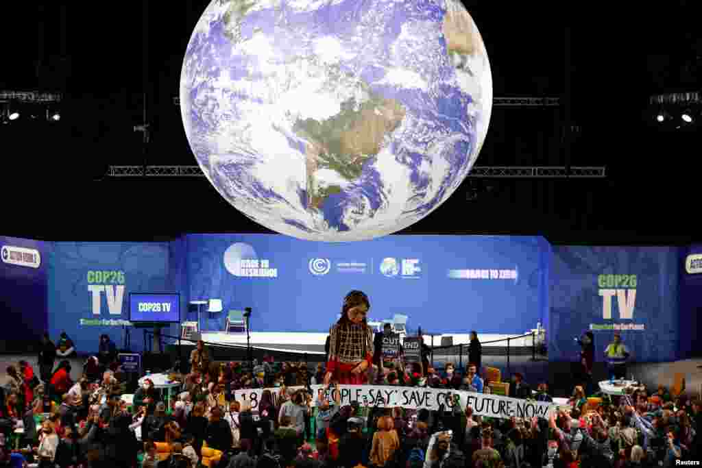 People gather around &quot;Little Amal&quot;, a 3.5meter-tall puppet depicting a young Syrian refugee girl, is seen at the U.N. Climate Change Conference (COP26) in Glasgow, Scotland.
