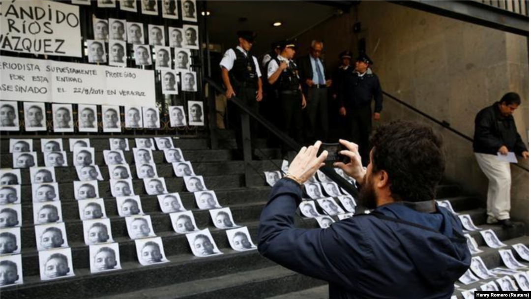 Foto de archivo de un hombre sacando una foto de imágenes del periodista Cándido Ríos, quien fue asesinado en Veracruz, durante una manifestación en el Ministerio del Interior en la capital de México. Ago 24, 2017. 