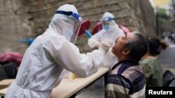 身穿防護衣的醫護人員在新疆地區進行新冠病毒的核酸檢測工作。