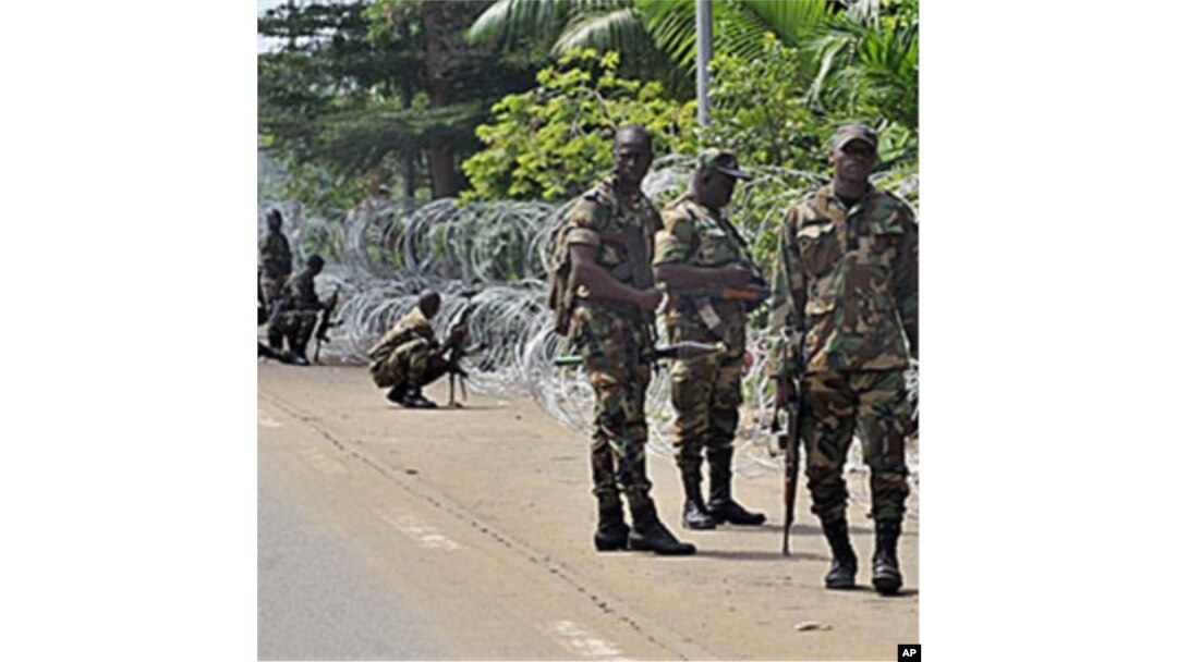 Armed members of the New Forces adopt combat positions near the hotel that houses the rival government declared by Alassane Ouattara in Abidjan, Ivory Coast, 13 Dec 2010