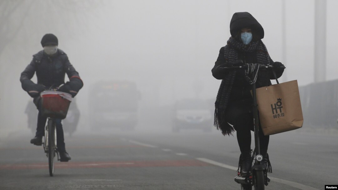 People ride amid the smog in Beijing, China, Feb. 14, 2017. 