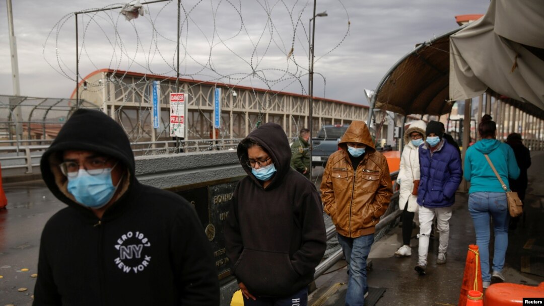 Migrantes deportados de Estados Unidos caminan hacia México por el puente fronterizo internacional Paso del Norte, en esta foto tomada desde Ciudad Juárez, México el 29 de enero de 2021. REUTERS / Jose Luis Gonzalez