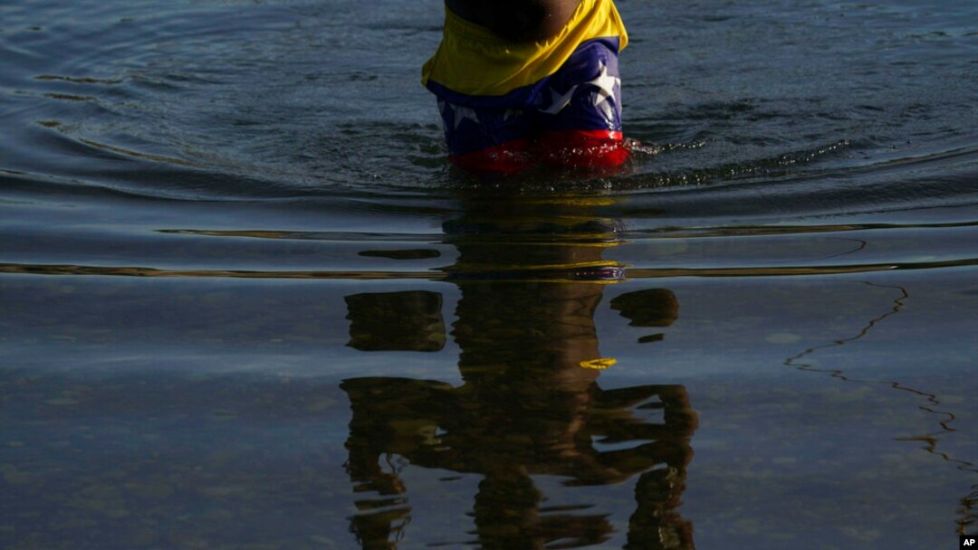 Un migrante con pantalones con un motivo de la bandera venezolana cruza el río Bravo desde Del Rio, Texas, para regresar a Ciudad Acuña, México, el 22 de septiembre de 2021.