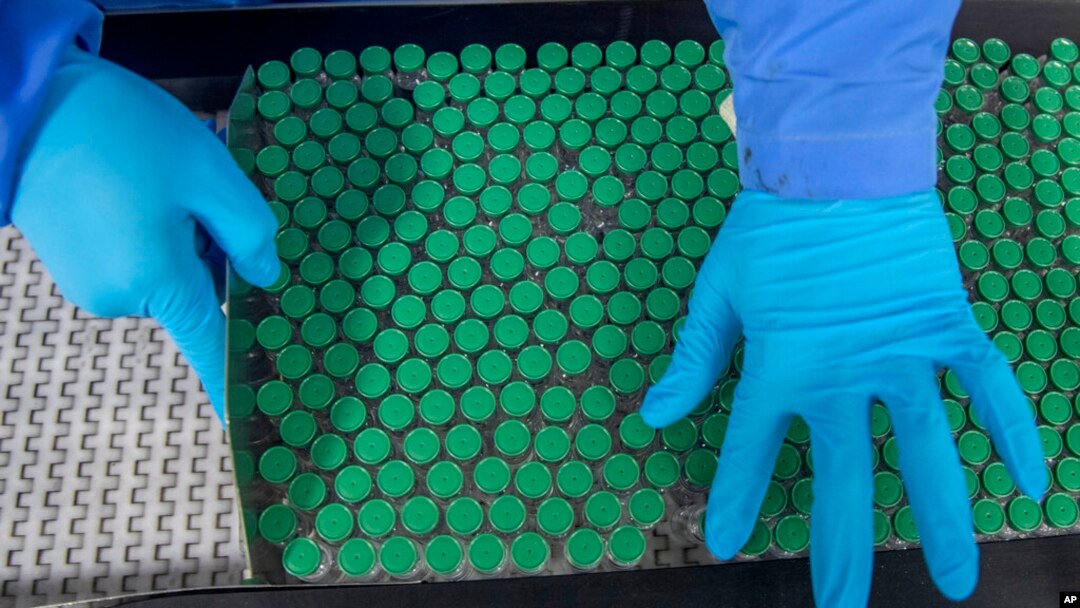 An employee packs a box containing vials of Covishield, a version of the AstraZeneca vaccine, at the Serum Institute of India in Pune, Nov. 22, 2021.