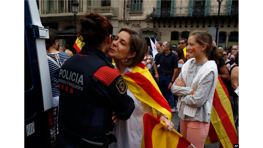Žena nosi španske i katalonske boje pozdravljajući lokalnog policajca, pripadnika Mosos eskuadre, dok ljudi proslavljaju Španski nacionalni dan u Barseloni, 12. oktobra 2017.