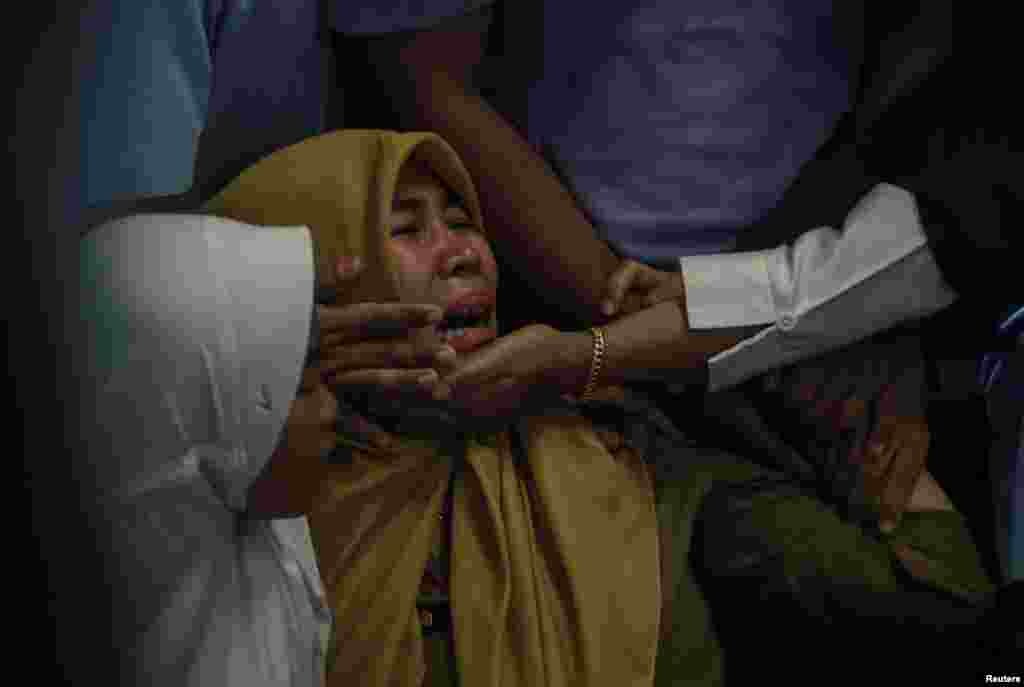 Relatives of passengers of Lion Air, flight JT610, that crashed into the sea cry at Depati Amir Airport in Pangkal Pinang, Belitung island,.