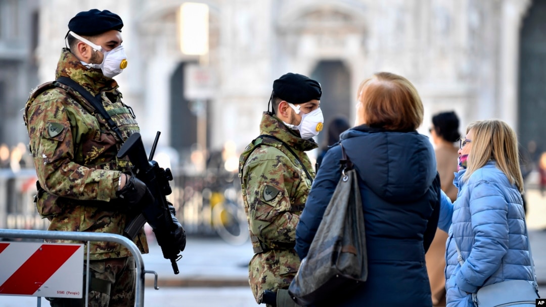 Italian soldiers wearing sanitary masks patrol Duomo square in downtown Milan, Italy, Monday, Feb. 24, 2020. 