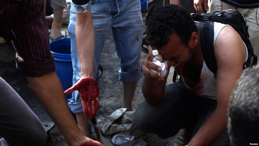 Supporters of deposed Egyptian president Mohamed Mursi mourn protesters who died during clashes with army soldiers as they touch blood on the ground in Cairo, July 8, 2013.