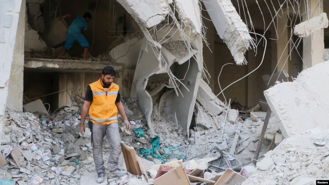 A Red Crescent aid worker inspects scattered medical supplies after an airstrike on a medical depot in the rebel-held Tariq al-Bab neighborhood of Aleppo, Syria, April 30, 2016. 