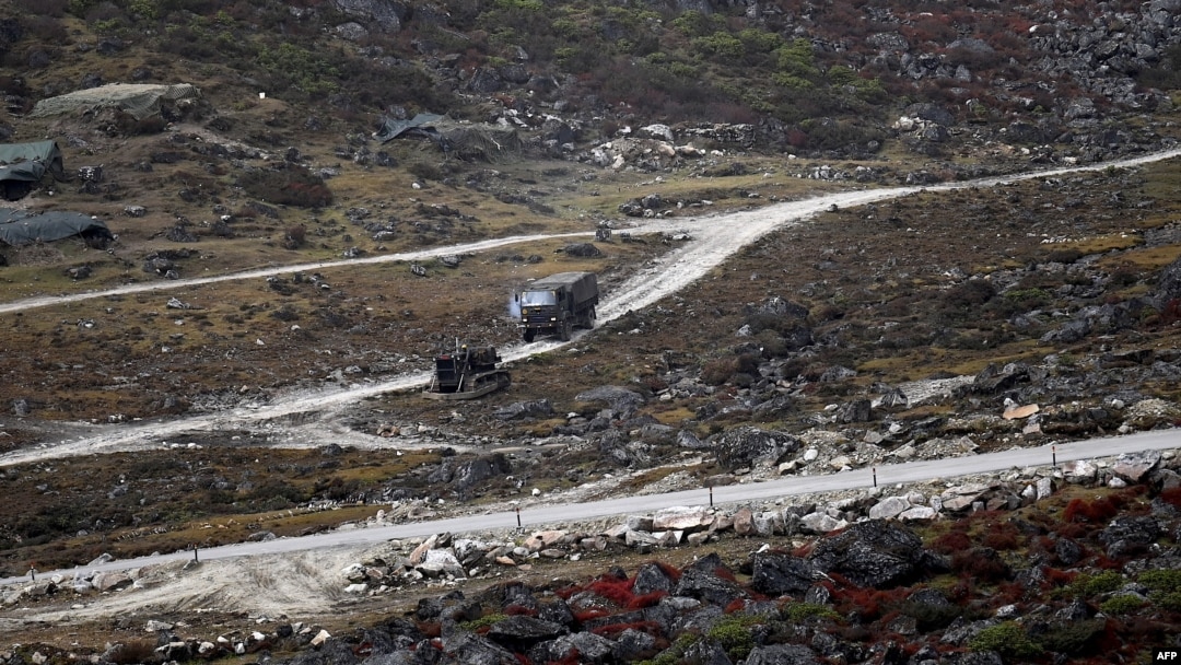 FILE - An Indian Army truck drives along a road to Tawang, near the Line of Actual Control (LAC), neighboring China, near Sela Pass in India's Arunachal Pradesh state, Oct. 21, 2021.