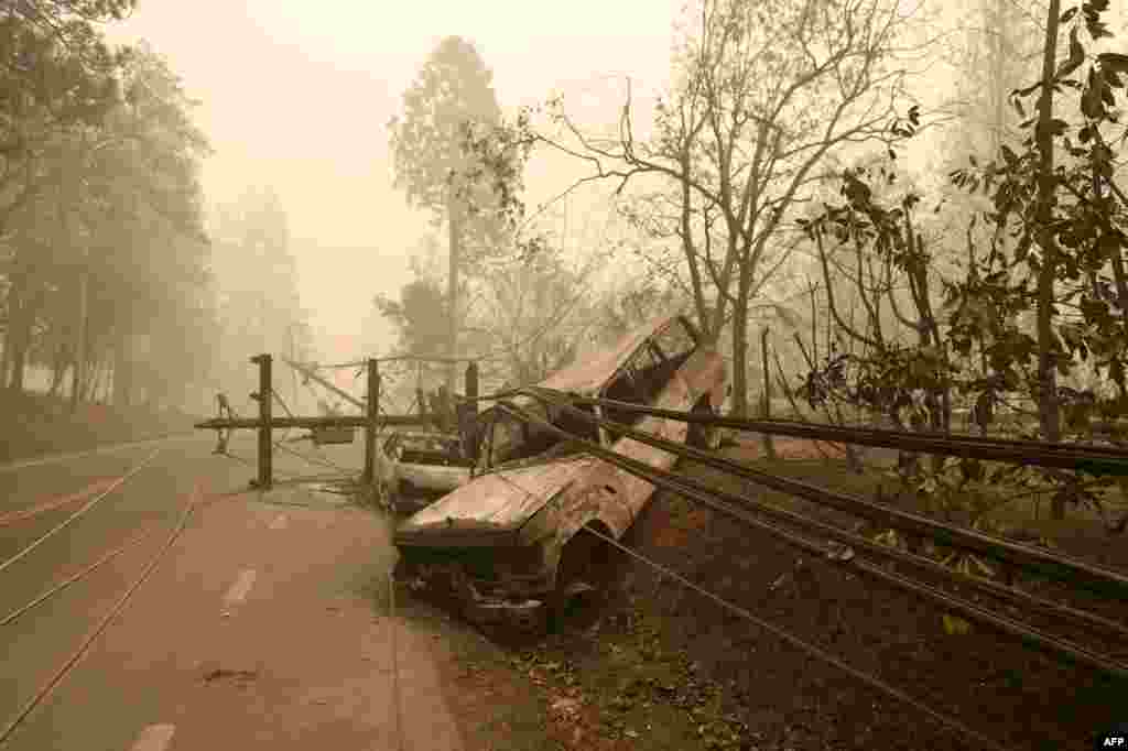 A fallen power line is seen on top of burnt out vehicles on the side of the road in Paradise, California after the Camp fire tore through the area, Nov. 10, 2018.
