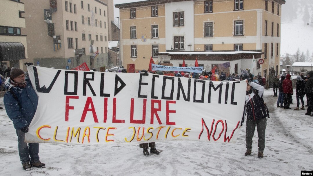 Climate activists display a banner during a protest ahead of the World Economic Forum (WEF) 2023 in the Alpine resort of Davos, Switzerland, Jan. 5, 2023. 