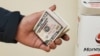 Un inmigrante salvadoreño se apresta a enviar dinero desde una agencia de envío en las afueras de Washington DC. Los centroamericanos envían montos diferenciados en promedio para cada país: 500 guatemaltecos, 370 salvadoreños y 330 hondureños. (Foto VOA / Tomás Guevara)