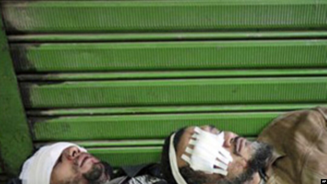 Anti-government demonstrators, wounded during clashes with pro-government protesters at a makeshift medical triage station, near Cairo's Tahrir square, February 2, 2011